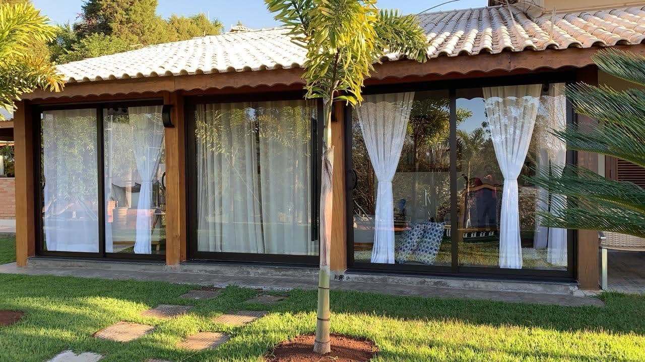 Fachada residencial com grandes vãos envidraçados